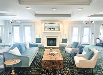 A living room with a fireplace and a television mounted above it.